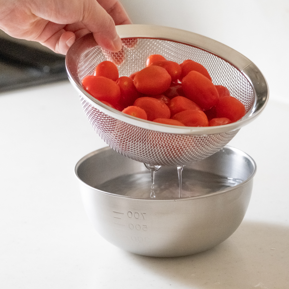 A deep bowl and a colander that won't let rice fall through